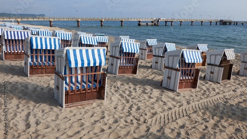 Strandkorb on Rugen beach with blue striped canopies lined along sandy shore