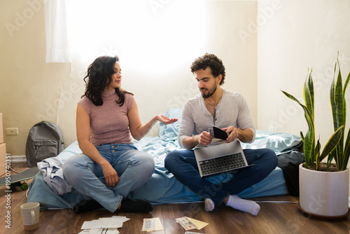 Latin poor couple struggling with finances in new first apartment, managing budget and paying bills on a limited income