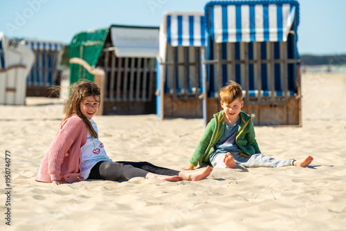 Photography Cute boy and girl sitting on sand at Baltic Sea beach in Germany