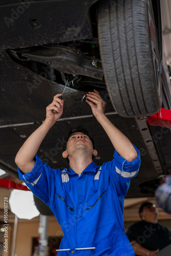 Mechanic inspecting car undercarriage during automotive service