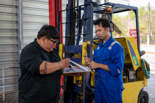 Mechanic team inspecting forklift for maintenance and repair