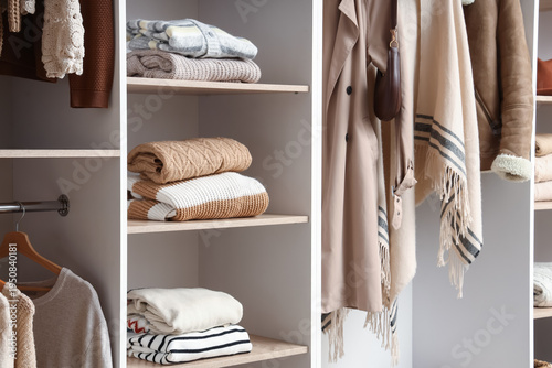 Warm sweaters on shelf in w...