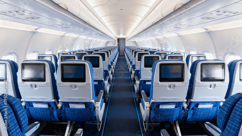  Wide view of modern empty passenger aircraft interior with blue economy seats, aisle, overhead bins and seatback screens. Travel, aviation, transport concept.