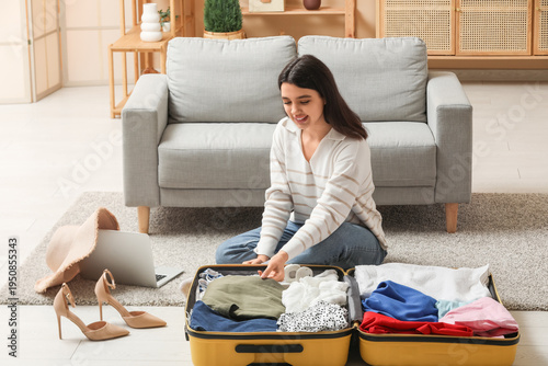Smiling young woman packing...