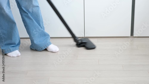 Black cordless vacuum cleaner on laminate flooring close-up.