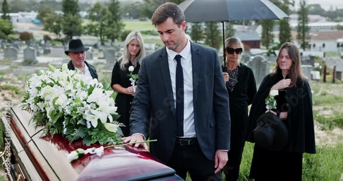 Man, casket and rose for respect at funeral with grief, goodbye or mourning with compassion at cemetery. Person, coffin and remembrance with white flower, farewell and burial service at graveyard