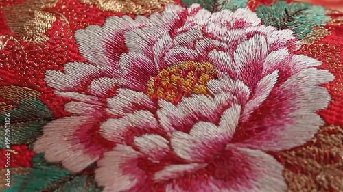 Detailed embroidery of a blooming flower on ornate fabric