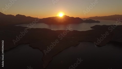 Wallpaper Mural Drone flying slowly over Musandam fjords at sunrise near the Strait of Hormuz between Oman and Iran, dramatic mountain silhouettes and calm sea in golden morning light. Torontodigital.ca