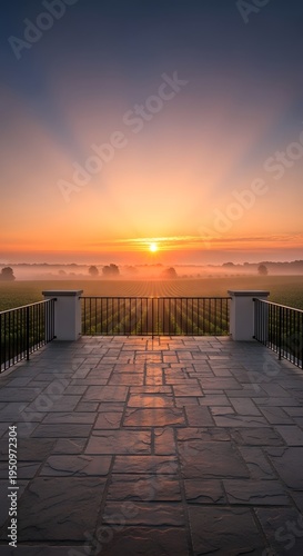 Beautiful sunrise view from a stone terrace overlooking a misty vineyard
