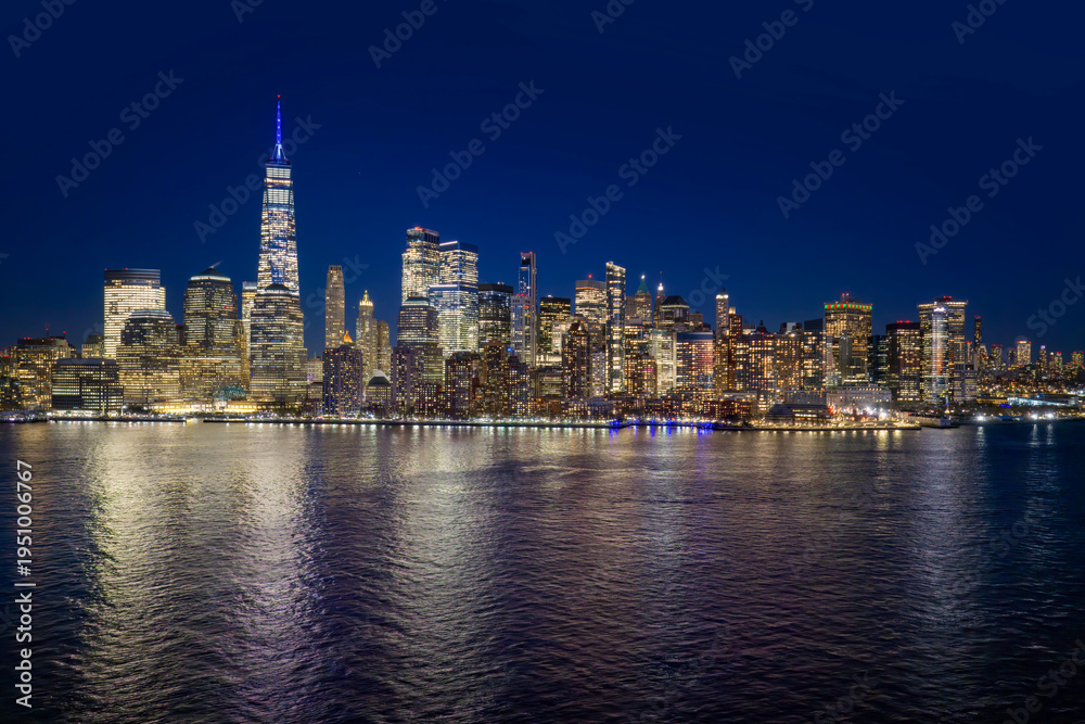 Obraz premium New York skyline at night. NYC night metropolis skyline view. New York as a big American city. New York City glowing at night. Manhattan skyline at night. Lower Manhattan aerial skyline view.