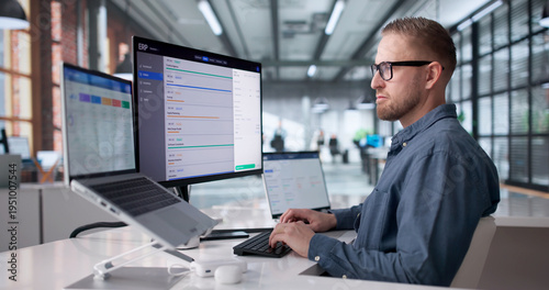 Foto Young Professional Managing Cloud-Based ERP Software On Laptop