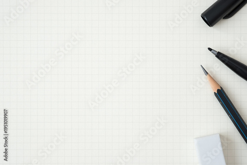 Top view, Close-up of Black Felt-tip Pen, Pencil and Eraser on Graph Paper Background, Copy Space for Text, Flat Lay Concept.