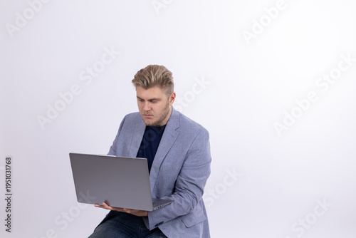 Young man working on laptop while looking at screen