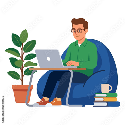 A man sits on a blue beanbag chair working on a laptop next to a plant.