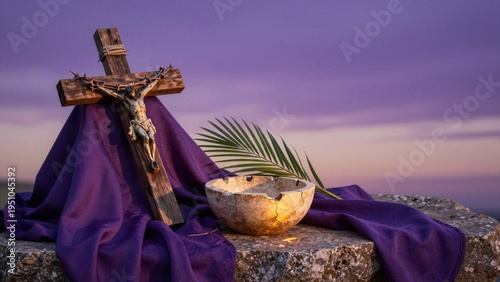 A crucifixion scene with Jesus on the cross, a cracked bowl of ashes, palm frond, and purple cloth against a soft focus sunset sky.