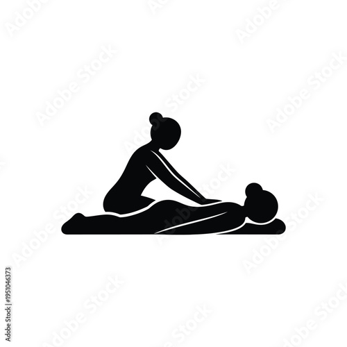 A woman gives a massage to a man on a mat indoors.