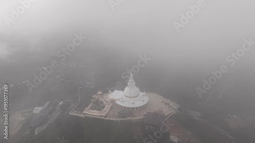 Buddhist temple on mountain in clouds Sri Lanka, mystical aerial drone view of sacred shrine above misty hills