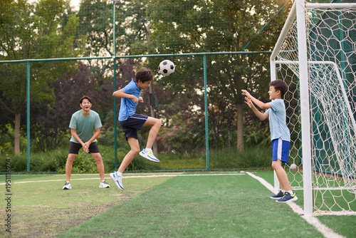 Boys play football under the coach's instruction