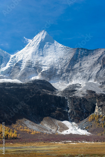 view of autumn highland snow mountain of Yading Nature Reserve, snow-capped mountains, crystal clear lakes, vast grasslands, colorful forests, Shangri-La Town, Daocheng, Sichuan, China