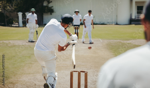 Cricket match with batsman hitting a fast ball on a sunny day
