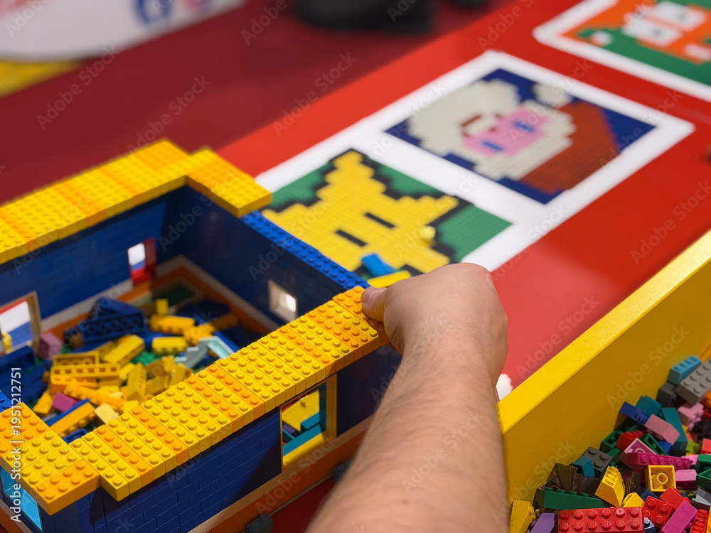Fototapeta premium Child building colorful toy brick structure on table
