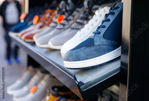 Variety of stylish sneakers displayed on shoe store shelf