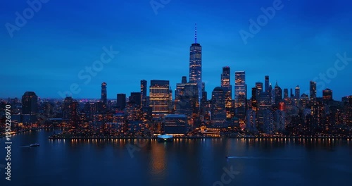 Ski jet and motor boat moves by the peaceful waterscape of the East River. Gorgeous skyline of New York, USA at sunset from the riverscape.