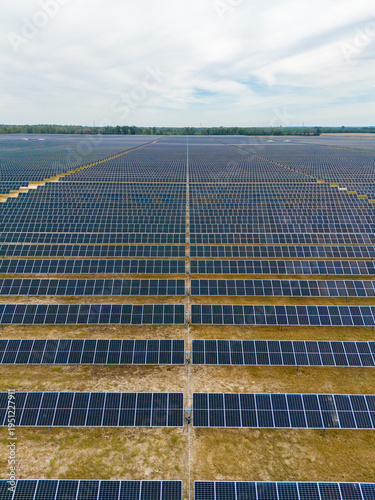 Aerial view of rows and rows of solar panels creating a stark geometric pattern against the light earth, Jasper, Florida, United States.