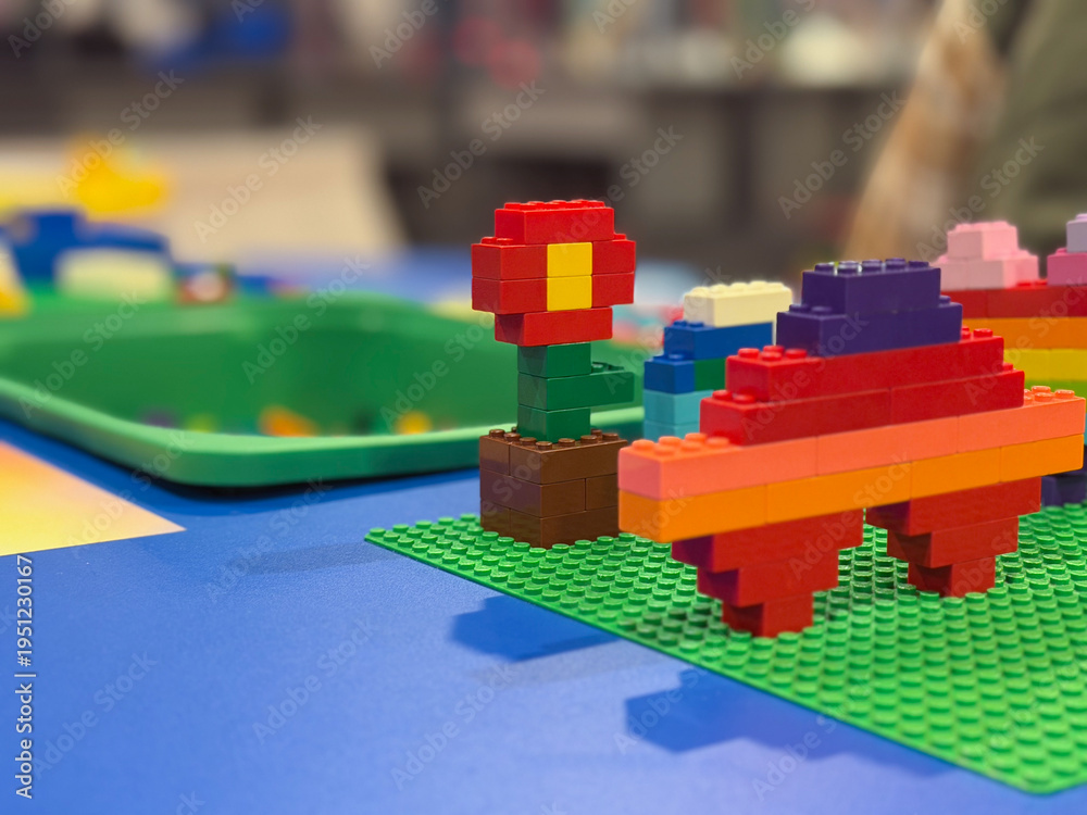 Fototapeta premium Colorful lego flower and vehicle on green baseplate