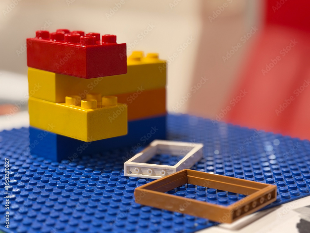 Naklejka premium Colorful plastic building blocks on blue baseplate