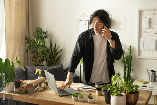 Φωτογραφία Young asian florist engaged in a lively conversation while managing a vibrant wo