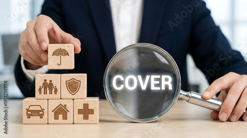 Insurance cover concept with magnifying glass highlighting cover and wooden blocks showing family shield car home health and umbrella protection