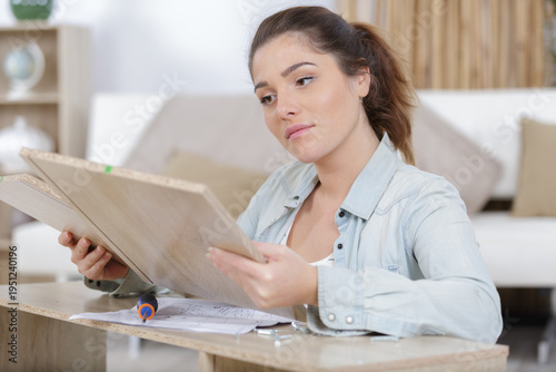 woman assembling furniture in new apartment