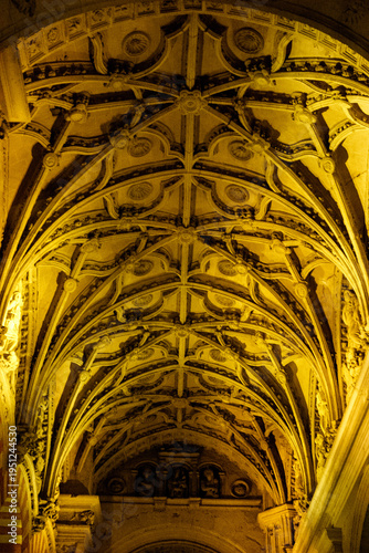 Photos The intricate ribbed vault ceiling of the Mezquita-Cathedral of Cordoba, Spain, illuminated by warm light
