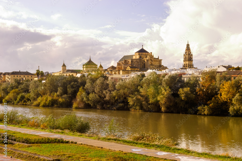 Obraz premium The Mezquita-Cathedral of Cordoba, Spain, seen across the Guadalquivir River during autumn.