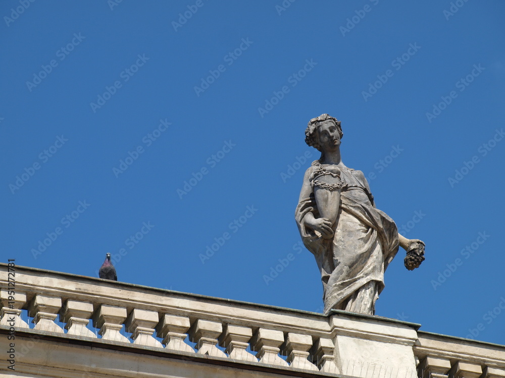 Fototapeta premium Elegant Stone Statue on Rooftop Against Clear Blue Sky in Warsaw's Łazienki Park