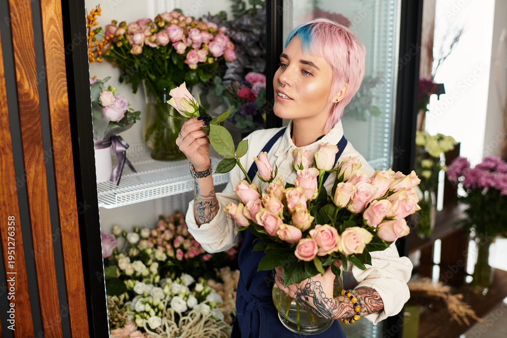 Fototapeta premium Young woman florists creates beautiful arrangements in her charming flower shop