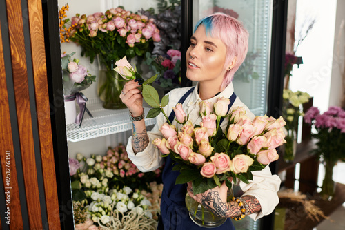 Fotografía Young woman florists creates beautiful arrangements in her charming flower shop