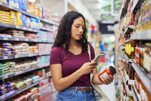 Konstfotografi Young woman scanning jar of cherry tomatoes for ingredients