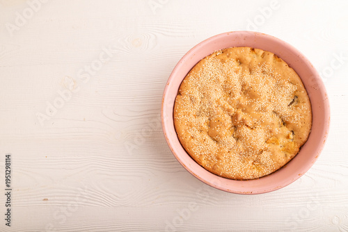Apple Charlotte cake in baking dish on white wooden, top view, flat lay, copy space