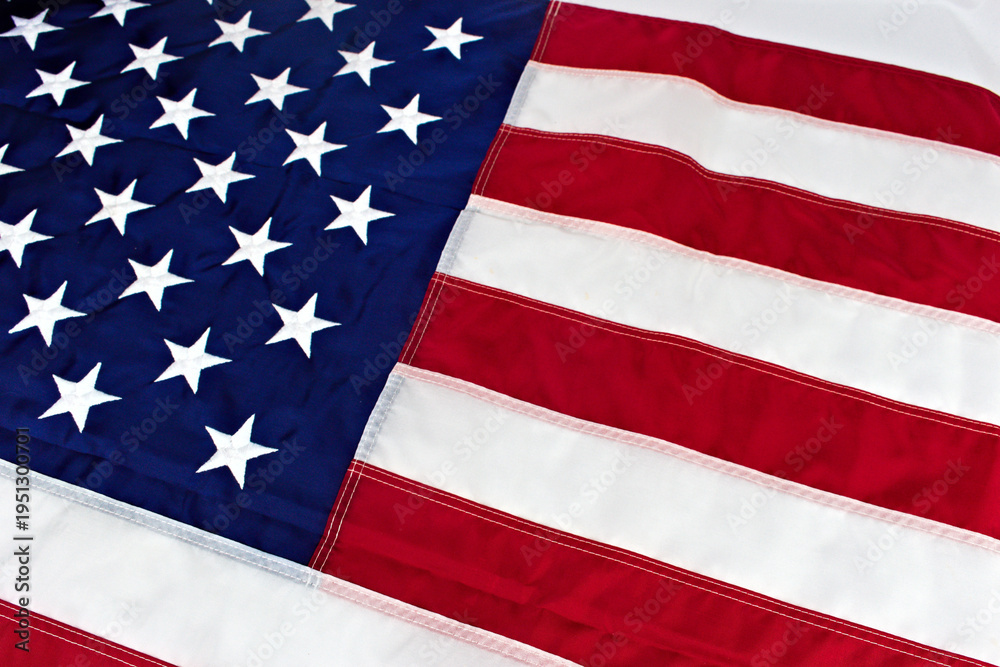 Obraz premium A detailed, close-up perspective of the United States flag, highlighting the texture and stitching of its iconic stars and stripes pattern