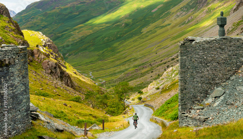 Canvastavla A bicycle rider peddles into Honister Pass,along a narrow,winding road,the Lake District,Cumbria,England,United Kingdom