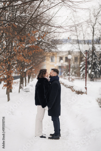 Konstfotografi Side view of couple in love holding hands while standing in snowy winter park an