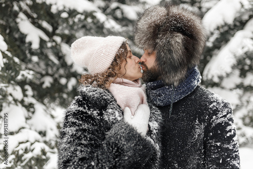 Canvastavla Side view of couple in love kissing in snowy winter park