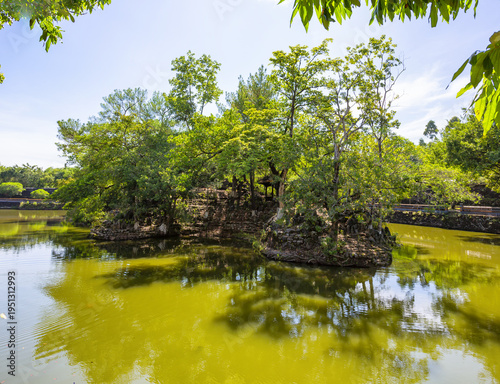 Title Traditional Vietnamese Pavilion and calm lake in a Hue Imperial Tomb park