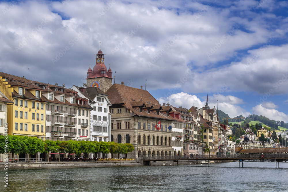 Obraz premium Embankment of Reuss river with historic buildings and colorful facades in Lucerne, Switzerland. Cloudy June sky in summer