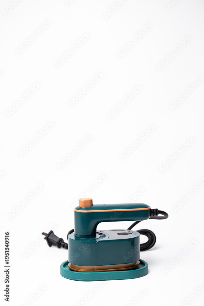 Fototapeta premium Teal Handheld Travel Steamer with Cork Knob on Base on a white background