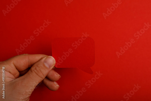 A hand holds a red speech b...