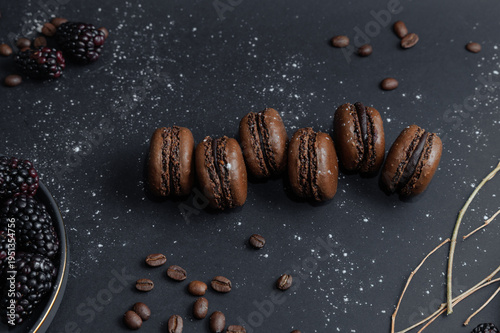 Chocolate Macarons with Blackberries, coffe beans on Dark Background