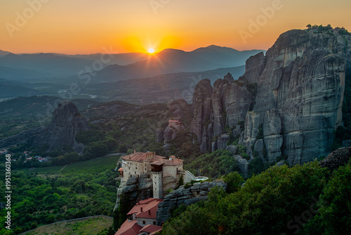 Sunset over the Meteora monasteries in Greece. Monastery of Rousanou in the foreground and St. Nikolaos Anapafsas Monastery in background. Beautiful landscape at dusk.